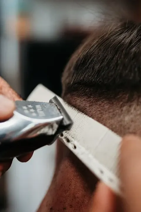 Barbero trabajando el degradado Barbero difuminando un degradado con la máquina de corte
