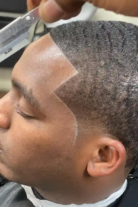 Contorno con navaja en la barbería Barbero marcando el contorno con navaja recta