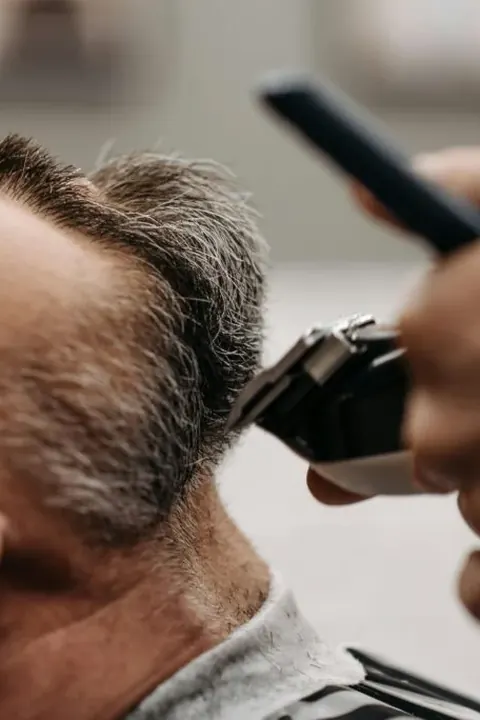 Conexión del taper fade con la barba Barbero perfilando la conexión entre el fade y la barba