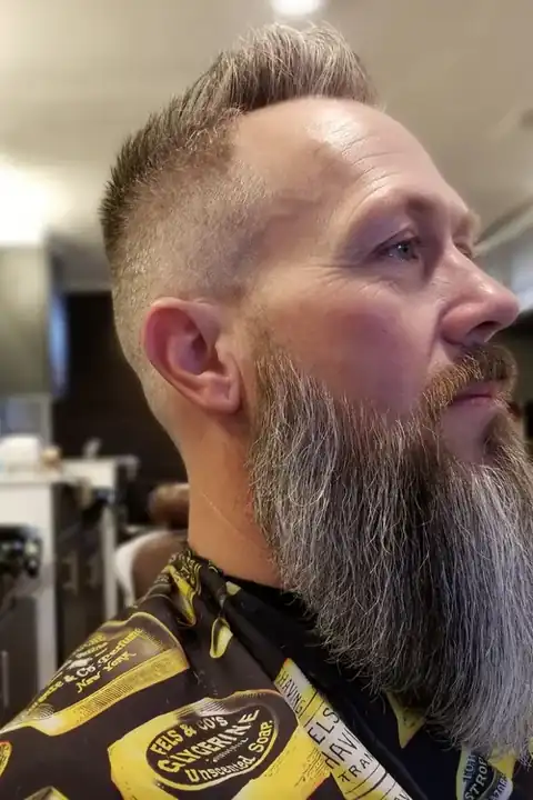 Taper fade con barba larga y poblada, contraste marcado
