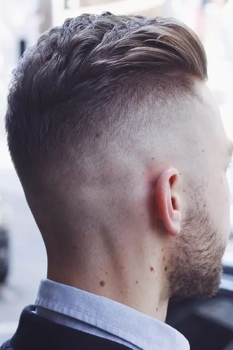Detalle del degradado suave de un taper fade en las patillas