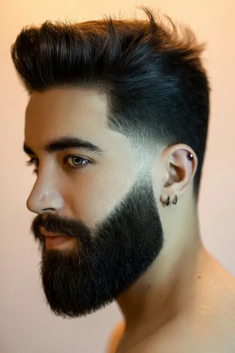 Taper fade con barba poblada y conexión marcada Taper fade con barba poblada y conexión marcada