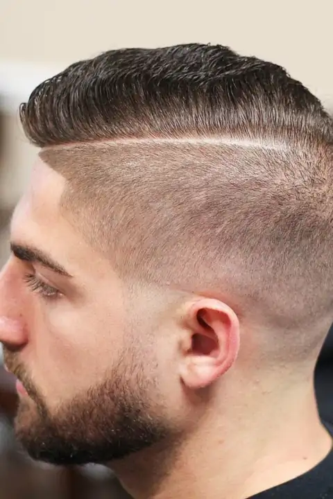 Taper fade con una sola línea diseñada al costado, estilo raya marcada