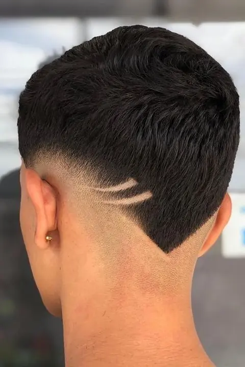 Taper fade con diseño en V en la nuca y doble línea lateral
