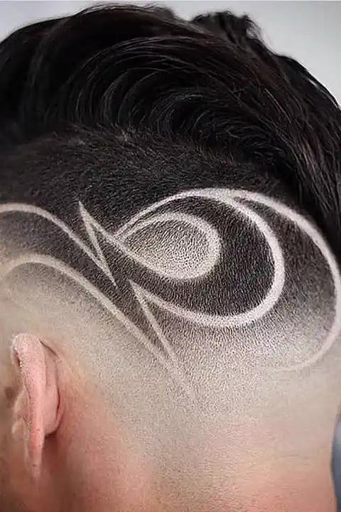 Taper fade con diseño tribal de curvas estilo remolino en el lateral