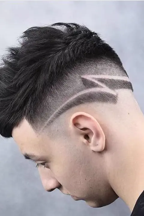 Taper fade con diseño de rayo o relámpago rapado en el lateral
