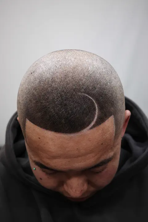 Corte rapado con diseño de media luna creciente en la parte superior