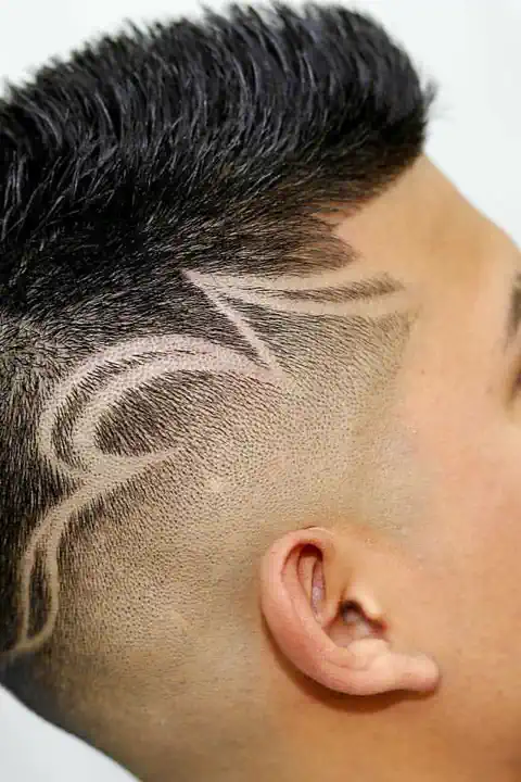 Taper fade con diseño de pluma rapada en el lateral