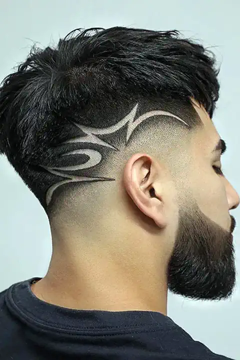 Taper fade con diseño freestyle asimétrico de curvas tribales en el lateral