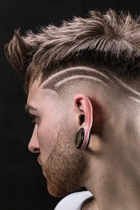 Taper fade con triple línea curva diseñada sobre fondo oscuro