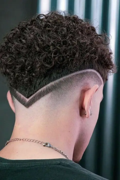 Taper fade rizado con diseño de ondas del lateral a la nuca