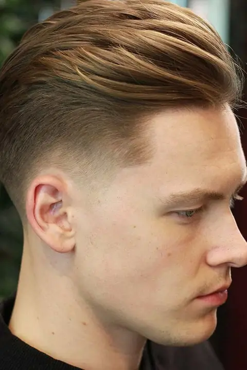 Taper fade clásico con el cabello peinado hacia un lado, estilo de referencia para el barbero