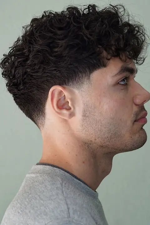 Taper fade rizado con rizos definidos arriba y lados degradados Taper fade rizado con rizos definidos arriba y lados degradados