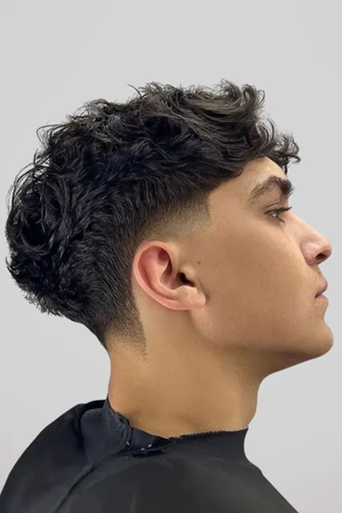 Mid taper fade ondulado de altura media en perfil lateral Mid taper fade ondulado de altura media en perfil lateral
